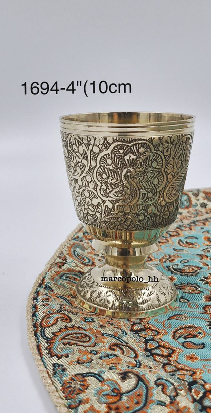 لیوان لوکس پایهدار طرح طاووس برنجی هندی کد 1694 با قلمزنی دستی و پایه تراشخورده متالوکس روی میز پذیرایی - بازرگانی نداف